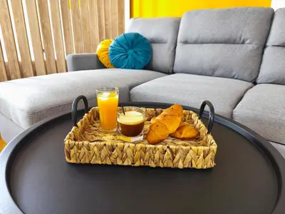 a table with a tray of food and two glasses of orange juice at Studio Σταθμός Λαρίσης 100Mbps , Μπαλκόνι in Athens