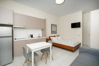 a kitchen and a living room with a bed and a table at Bed & Flight in Markopoulo