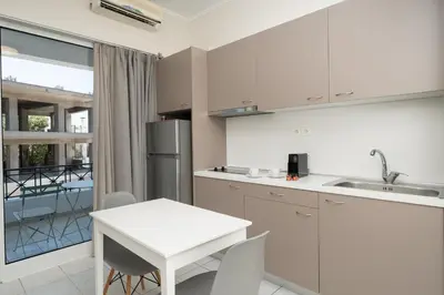 a kitchen with white cabinets and a white table at Bed & Flight in Markopoulo