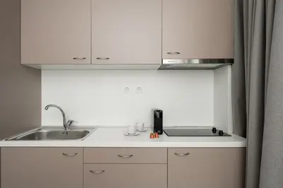 a kitchen with white cabinets and a sink at Bed & Flight in Markopoulo