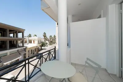 a balcony with a white chair and a table at Bed & Flight in Markopoulo