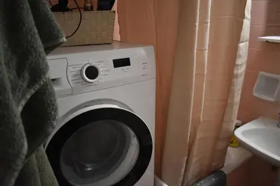 a washing machine in a bathroom next to a sink at Goudi Athens Retreat in Athens
