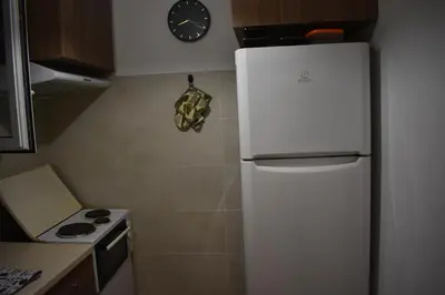 a white refrigerator in a kitchen with a clock on the wall at Goudi Athens Retreat in Athens