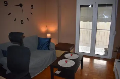 a living room with a couch and a clock on the wall at Goudi Athens Retreat in Athens