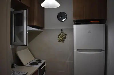 a kitchen with a refrigerator and a clock on the wall at Goudi Athens Retreat in Athens