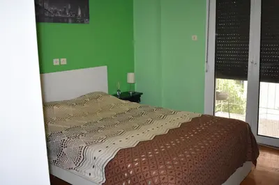 a bedroom with a bed and a green wall at Goudi Athens Retreat in Athens