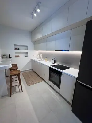 a kitchen with white cabinets and a sink and a stool at Luxury 2bedroom Apartment in Glyfada- Scarlet Vibes Glyfada in Athens