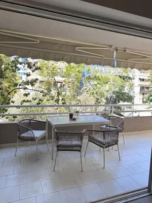 a patio with a table and chairs and a large window at Luxury 2bedroom Apartment in Glyfada- Scarlet Vibes Glyfada in Athens