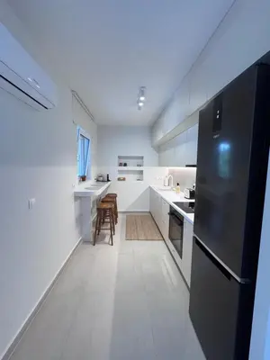 a kitchen with white counters and a black refrigerator at Luxury 2bedroom Apartment in Glyfada- Scarlet Vibes Glyfada in Athens
