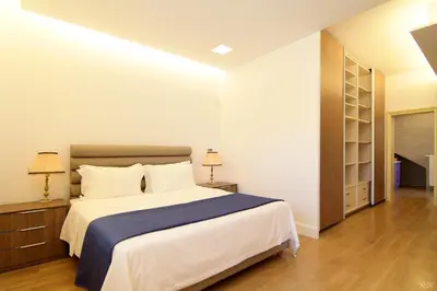 a bedroom with a large bed with a blue blanket at Villa Nelmar in Anavissos