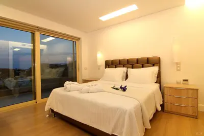 a bedroom with a large bed with two towels on it at Villa Nelmar in Anavissos