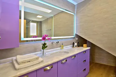 a purple bathroom with a sink and a mirror at Villa Nelmar in Anavissos