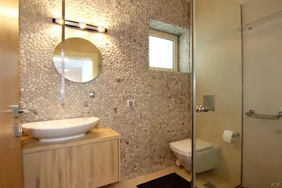 a bathroom with a sink and a toilet and a mirror at Villa Nelmar in Anavissos