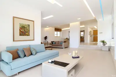 a living room with a blue couch and a table at Villa Nelmar in Anavissos