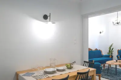 a dining room with a table and a blue couch at Archive, The Art of Living in Athens