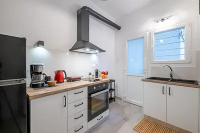 a kitchen with white cabinets and a black refrigerator at Archive, The Art of Living in Athens