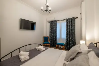 a bedroom with a large bed with a tv on the wall at Archive, The Art of Living in Athens