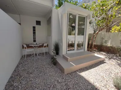 a white house with a table and a window at Viktoria's Garden Pavilion in Athens