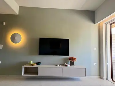 a living room with a tv on a wall at Diana Seaside Apartment in Anavissos