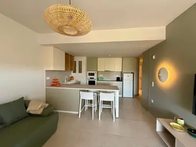 a kitchen and living room with a couch and a table at Diana Seaside Apartment in Anavissos