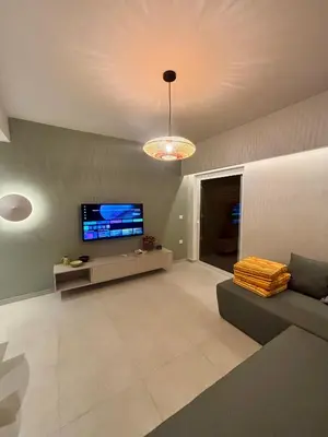 a living room with a couch and a flat screen tv at Diana Seaside Apartment in Anavissos