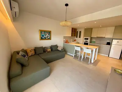 a living room with a couch and a kitchen at Diana Seaside Apartment in Anavissos