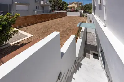 a backyard with a white fence and a pathway at Φωτεινό σπίτι 200μ από την παραλία in Porto Rafti