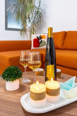 a bottle of wine and two glasses on a table at Φωτεινό σπίτι 200μ από την παραλία in Porto Rafti