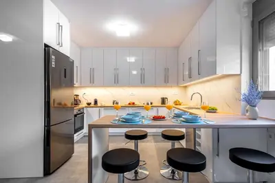 a kitchen with a island with stools and a counter top at Φωτεινό σπίτι 200μ από την παραλία in Porto Rafti
