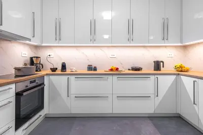 a kitchen with white cabinets and wooden counter tops at Φωτεινό σπίτι 200μ από την παραλία in Porto Rafti