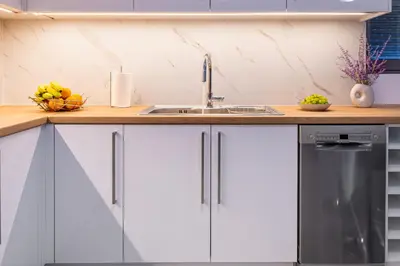 a kitchen with white cabinets and a sink at Φωτεινό σπίτι 200μ από την παραλία in Porto Rafti