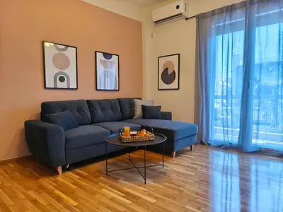 a living room with a blue couch and a table at Cosy apartment next to Larissa station 100Mbps & Balcony in Athens
