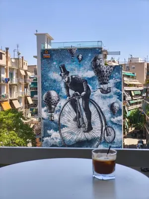 a picture of a man on a bike and a drink at Cosy apartment next to Larissa station 100Mbps & Balcony in Athens
