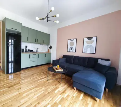 a living room with a blue couch and a table at Cosy apartment next to Larissa station 100Mbps & Balcony in Athens