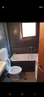 a bathroom with a toilet and a bath tub at Pallini house in Pallíni