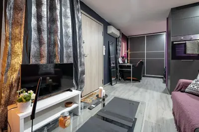 a living room with a couch and a tv at Lilac Dream in Glyfada by ΜΡS in Athens