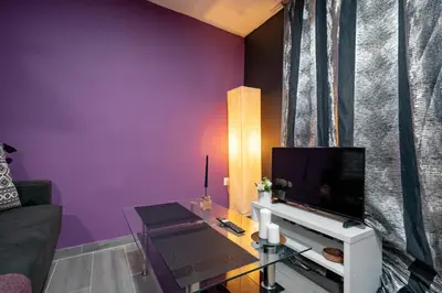 a living room with purple walls and a flat screen tv at Lilac Dream in Glyfada by ΜΡS in Athens