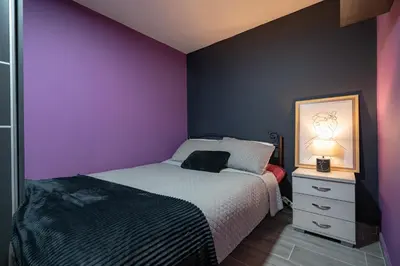 a bedroom with a bed and a purple wall at Lilac Dream in Glyfada by ΜΡS in Athens