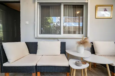 a couch sitting on a porch with two tables at Boho Nest in Glyfada by ΜΡS in Athens