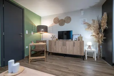 a living room with a tv and a table and a desk at Boho Nest in Glyfada by ΜΡS in Athens