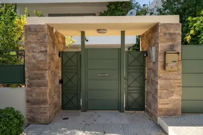 a green garage door in front of a house at Boho Nest in Glyfada by ΜΡS in Athens