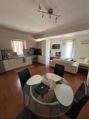a living room with a glass table and chairs at Elegant Flat in Elliniko with Sea View & Parking in Athens