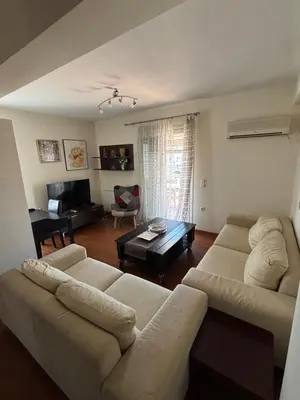 a living room with a couch and a table at Elegant Flat in Elliniko with Sea View & Parking in Athens