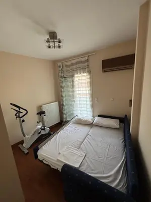 a bedroom with a bed and a treadmill next to a window at Elegant Flat in Elliniko with Sea View & Parking in Athens