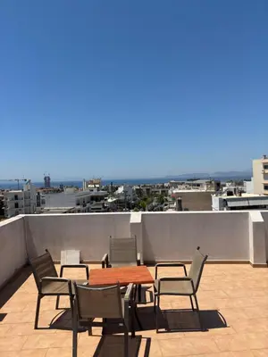 a table and chairs on a roof with a view at Elegant Flat in Elliniko with Sea View & Parking in Athens