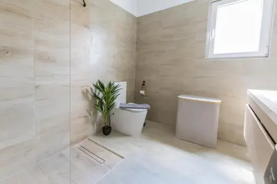 a bathroom with a toilet and a plant in it at Raise Coastal Grand Escape in Athens