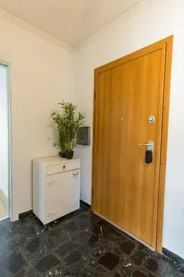 a room with a wooden door and a plant on a dresser at Raise Coastal Grand Escape in Athens