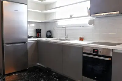 a kitchen with stainless steel appliances and a sink at The Brightline Apartment Athens in Athens