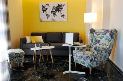a living room with a couch and a chair at The Brightline Apartment Athens in Athens