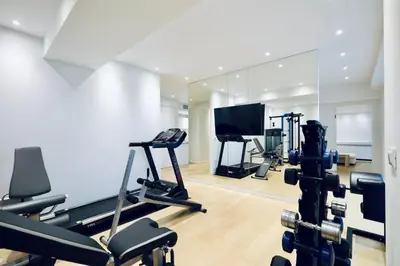 a gym with treadmills and a flat screen tv at Athens Riviera, 2 Pools & Gym Luxury Residence 310m2 in Athens